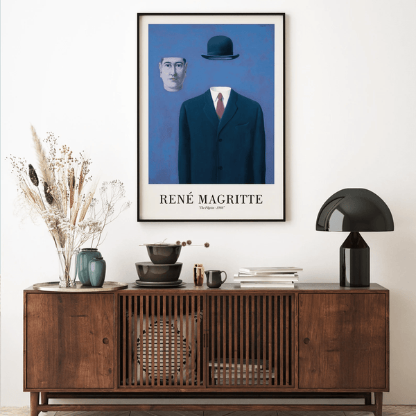 René Magritte plakat med surrealistisk mand i jakkesæt uden hoved og en svævende bowlerhat på blå baggrund.