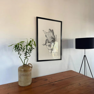 Humor plakat til badeværelset med illustration af en frø, der sidder på toilettet og læser avis i sort-hvid stil.