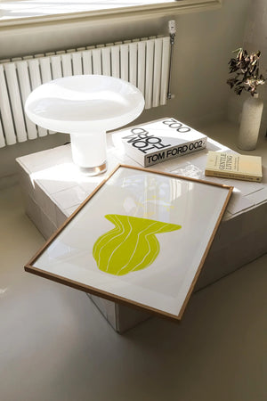 Plakat med grøn organisk form og fine linjer på lys baggrund i moderne indretning