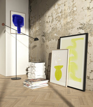 Plakat med grøn organisk form og fine linjer på lys baggrund i moderne indretning