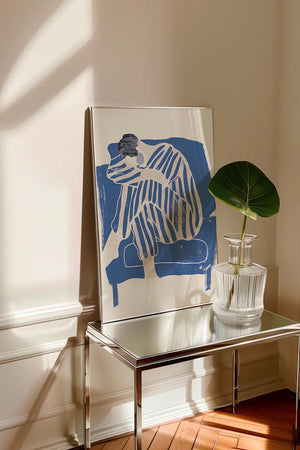 Kunstnerisk plakat med siddende figur i blå striber og bløde former på lys baggrund