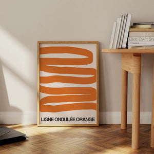 Grafisk plakat med bølgende orange former på lys baggrund i moderne indretning