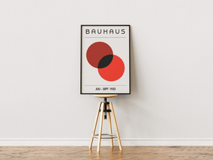 Bauhaus plakat med to overlappende cirkler i dyb rød og sort i minimalistisk geometrisk design.