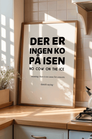 Plakat med teksten “Der er ingen ko på isen” og engelsk forklaring, minimalistisk dansk citatplakat i sort typografi.