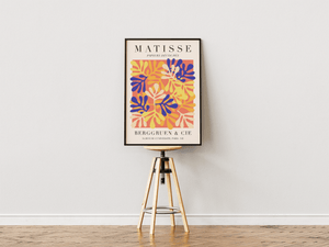 Colorful Paper Shapes Matisse plakat med farverige cut-out blade i blå, gul og orange.