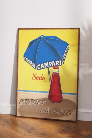 Vintage Campari Soda plakat med rød flaske og blå parasol på strand – retroreklame med teksten "Éteint la soif"