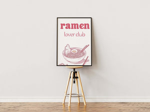Plakat med ramen-skål, spisepinde og teksten “Ramen Lover Club” i lys træramme – sjov og dekorativ madplakat til køkkenet.