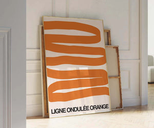 Grafisk plakat med bølgende orange former på lys baggrund i moderne indretning