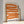 Grafisk plakat med bølgende orange former på lys baggrund i moderne indretning