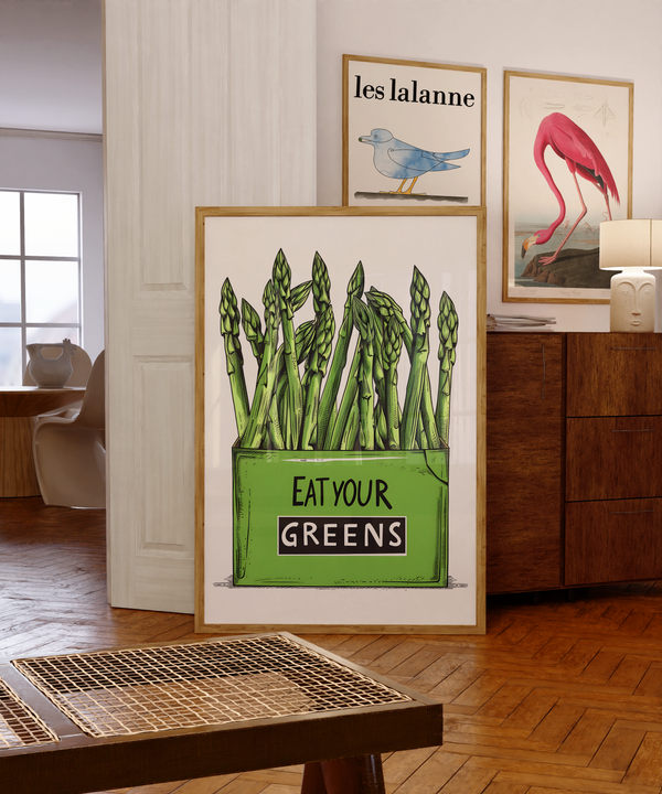 Køkkenplakat med grønne asparges og teksten "Eat Your Greens" i en træramme – sjov og farverig vægdekoration til køkkenet.