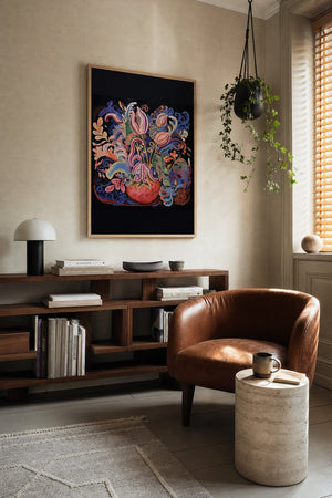 Blomstervase i ornamentik plakat i mørk ramme over sideboard i stue