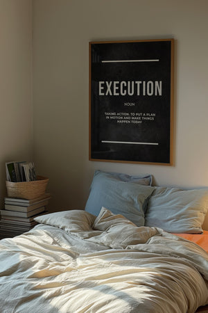 Execution Definition plakat med stor typografi på sort baggrund i egetræsramme over seng