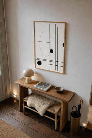 Geometrisk balance plakat i sort ramme ved sidebord i moderne stue