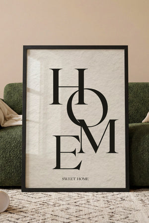 Hjem kært hjem typografiplakat i egetræsramme ved sofa