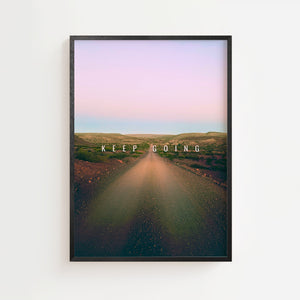 Keep Going plakat med vej gennem tørt landskab i lyserøde og blå toner, sort ramme