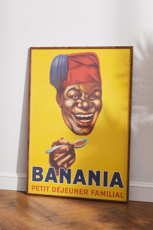 Vintage Banania plakat med smilende mand og ske – fransk retroreklame i gule og røde farver med teksten "Petit Déjeuner Familial".


