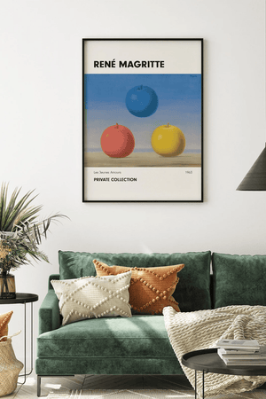 René Magritte plakat med tre æbler i blå, rød og gul i surrealistisk stil på lys baggrund.

