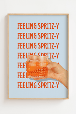 Plakat med teksten "Feeling Spritz-y" i rød-orange skrift gentaget på lyseblå baggrund, med en hånd der holder et glas Aperol Spritz.

