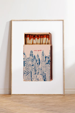 Plakat med New York tændstikæske i retro stil og illustration af storbyens skyline.

