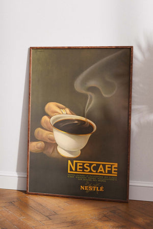 Vintage plakat med Nescafé reklame – retro kaffekop og dampsky i brun og gylden farveskala
