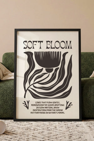 Soft Bloom plakat med grafisk blomstermotiv i sort og hvidt i egetræsramme ved sofa