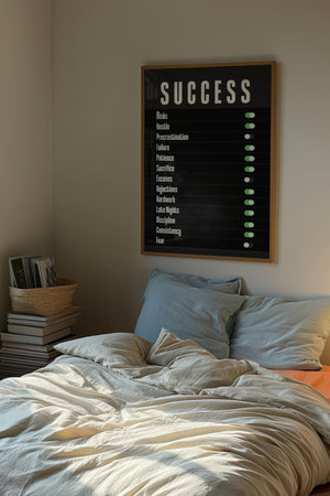 Success kontrolpanel plakat med hvid typografi og grønne knapper på sort baggrund i egetræsramme over seng