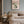 Tulipaner i stribet vase plakat i lys ramme over sidebord i stue